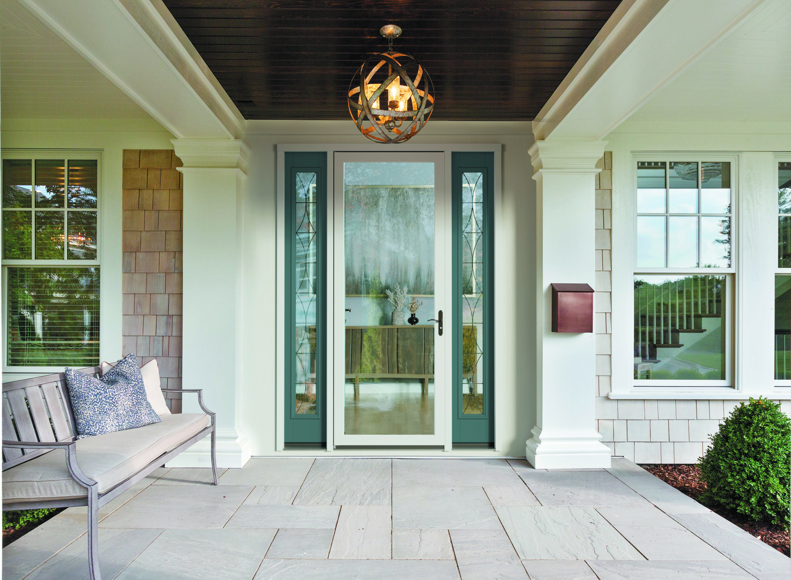 Stone front porch and wood door with vertical windows on each side of the door